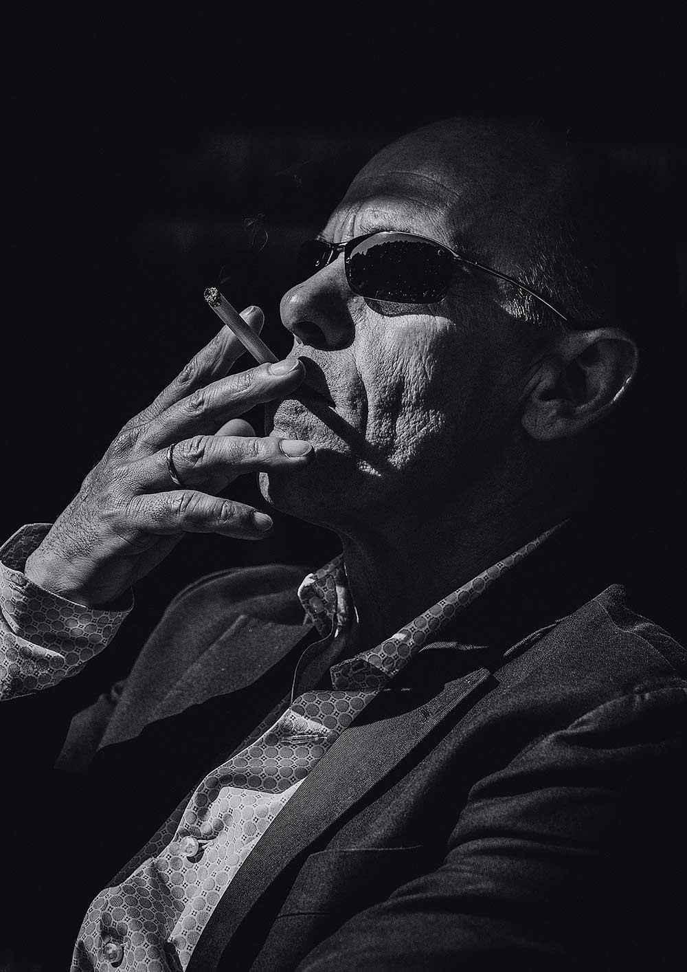 old man smoking a joint in grayscale