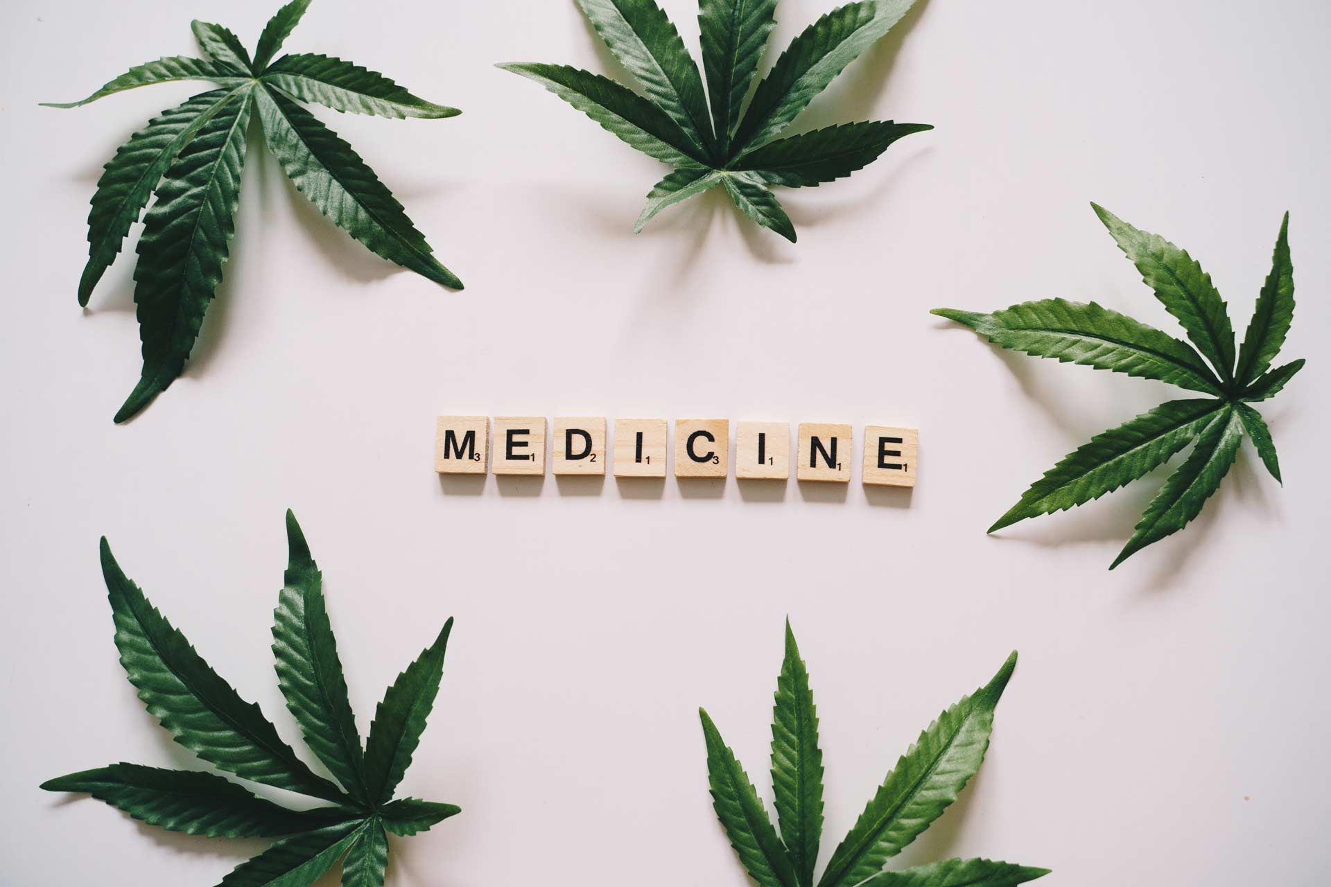 scrabble letters spell medicine with cannabis leaf surrounding